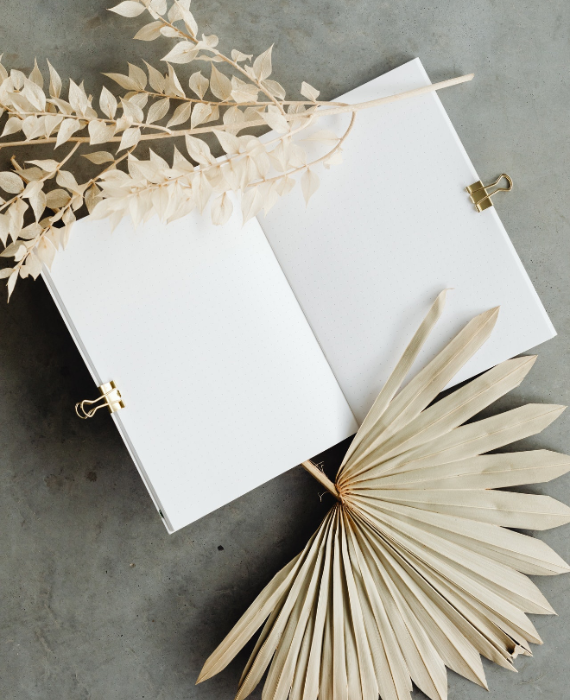 Image d'un livre avec deux pages blanches et des fleurs sur les côtés